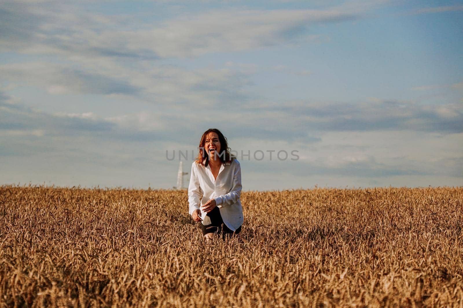 Happy woman runs in a wheat field on a summer day. Happiness and joy concept by natali_brill