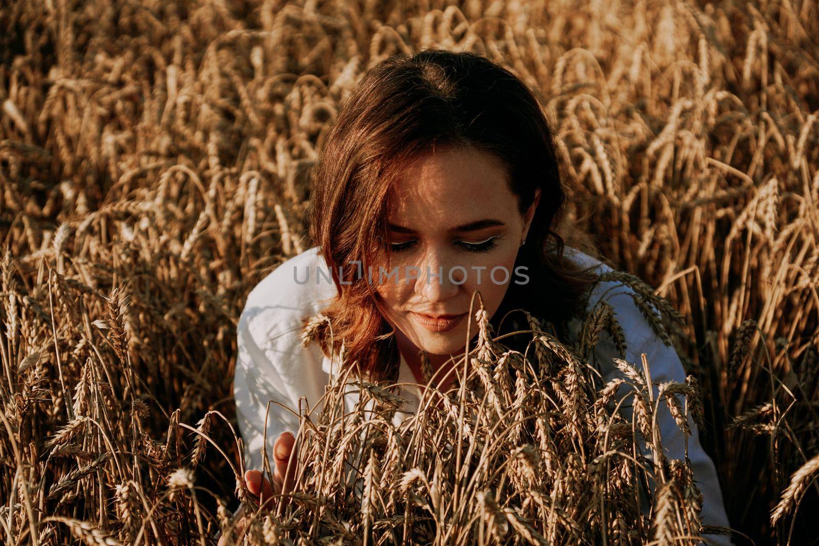 Redhead beautiful woman in a rye field. She breathes in the scent of fresh ears by natali_brill