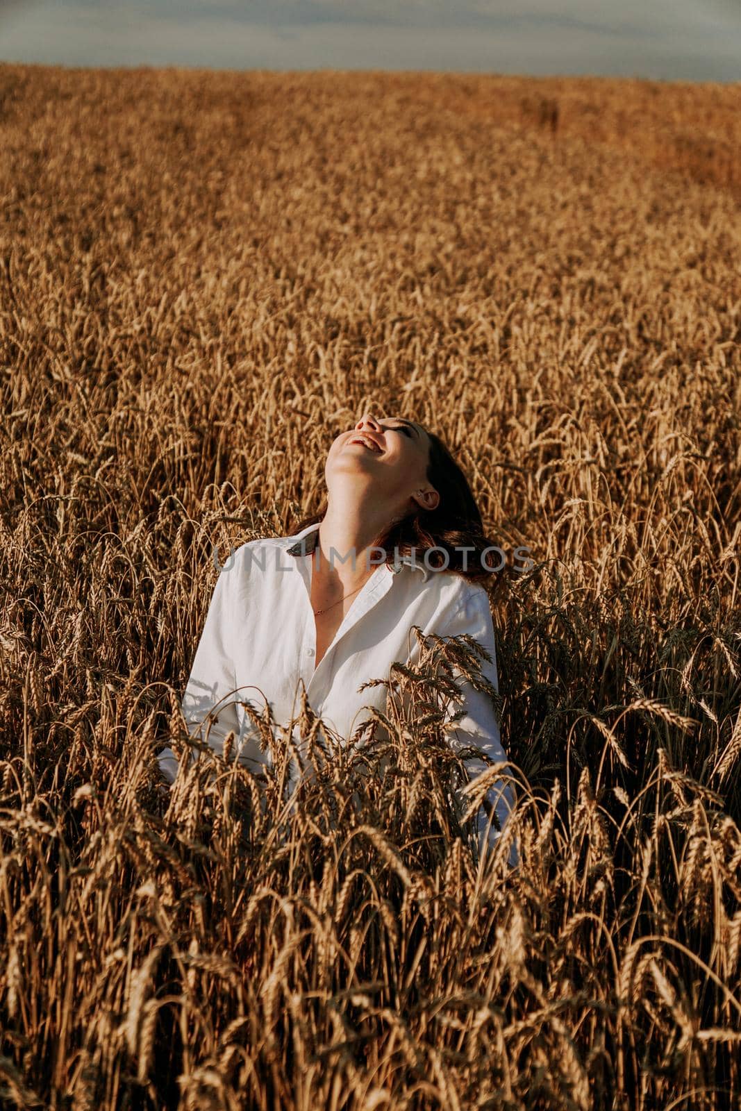 Summer nature, summer holidays, vacation and people concept. Close up of happy young woman in the ears of a rye field