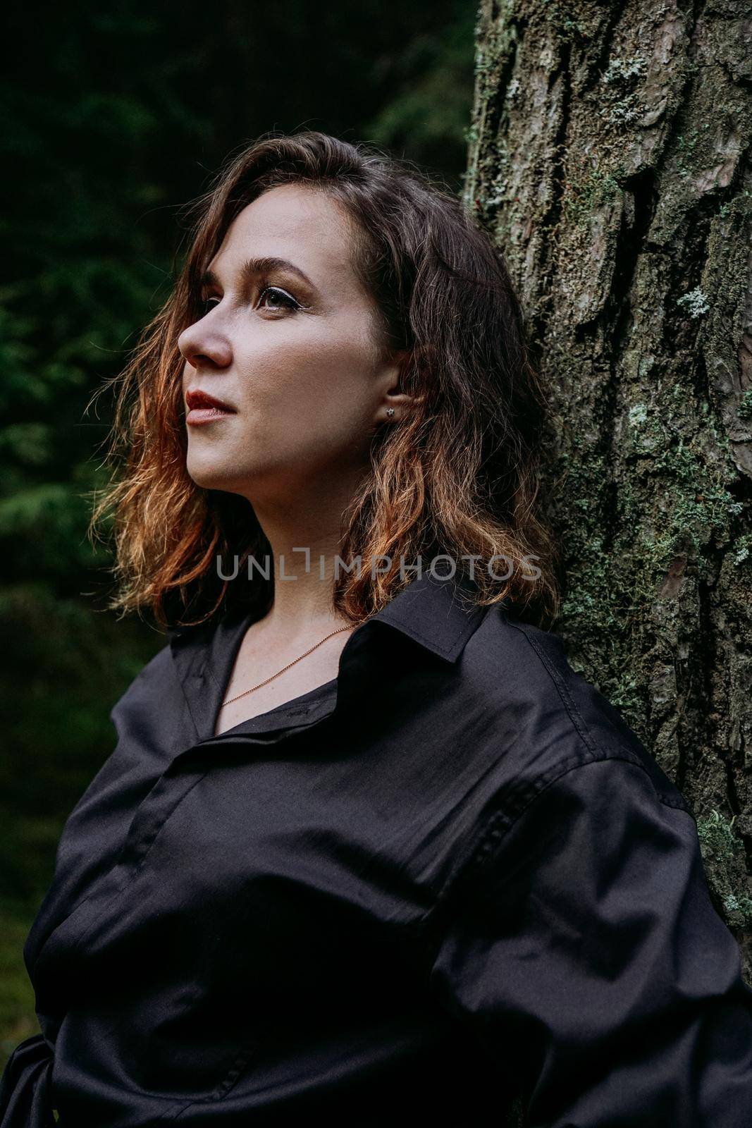 Young woman - close portrait in a dark forest. Woman in black shirt by natali_brill