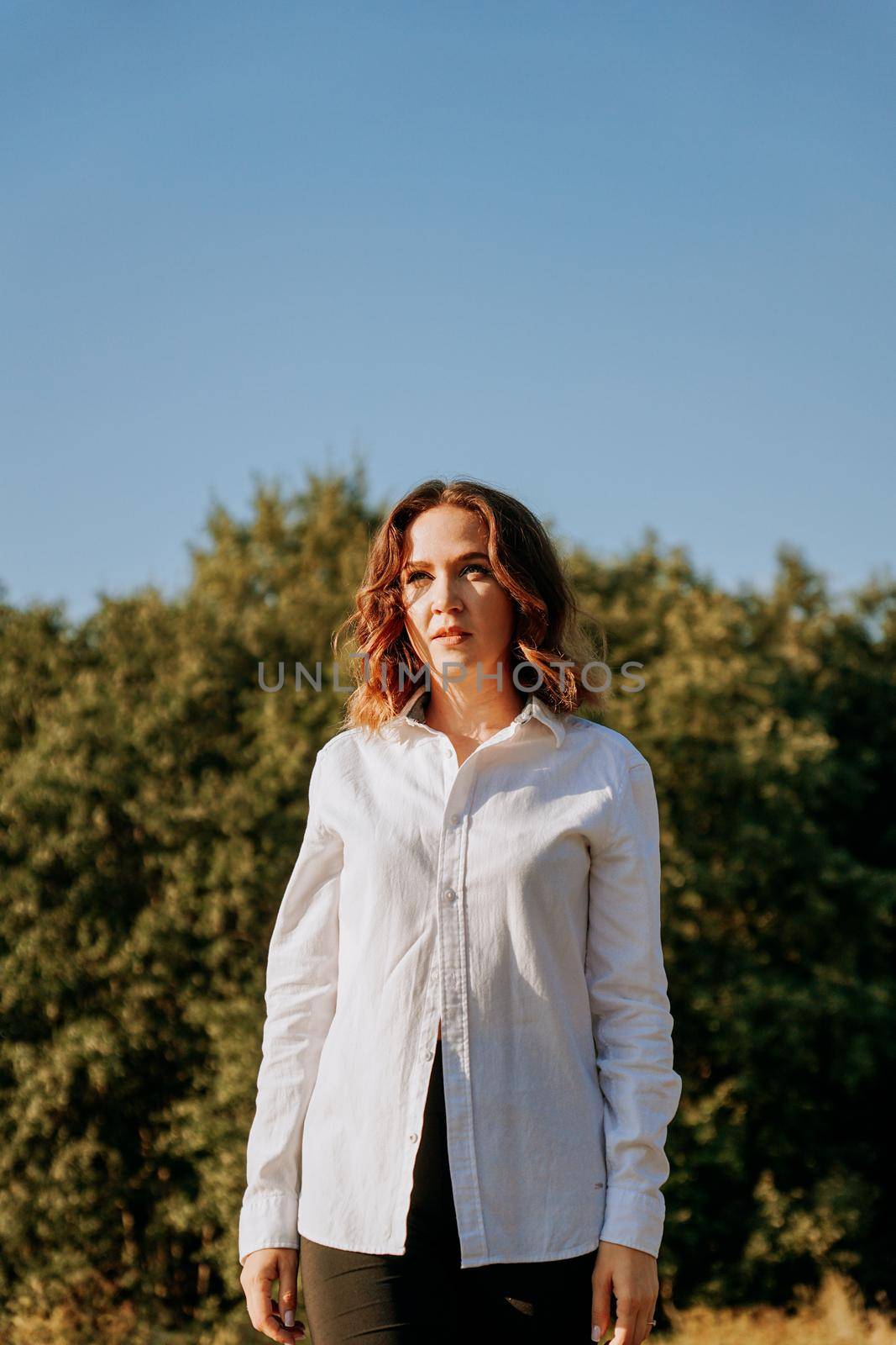 Woman in a white shirt on a natural background. Walk in the forest. Happy young woman