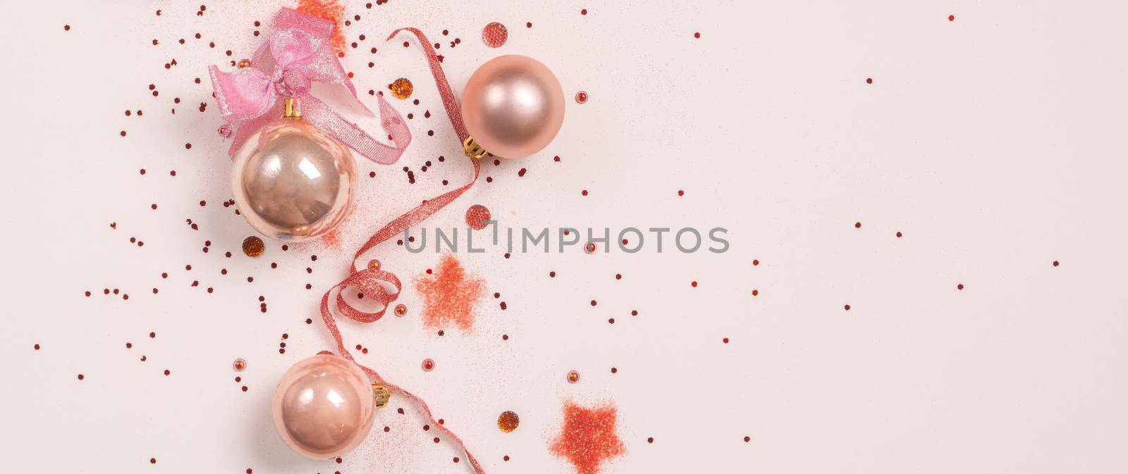 Panorama of Christmas composition. Christmas balls, pink and golden decorations on pink background. Flat lay, top view, copy space by Mariakray