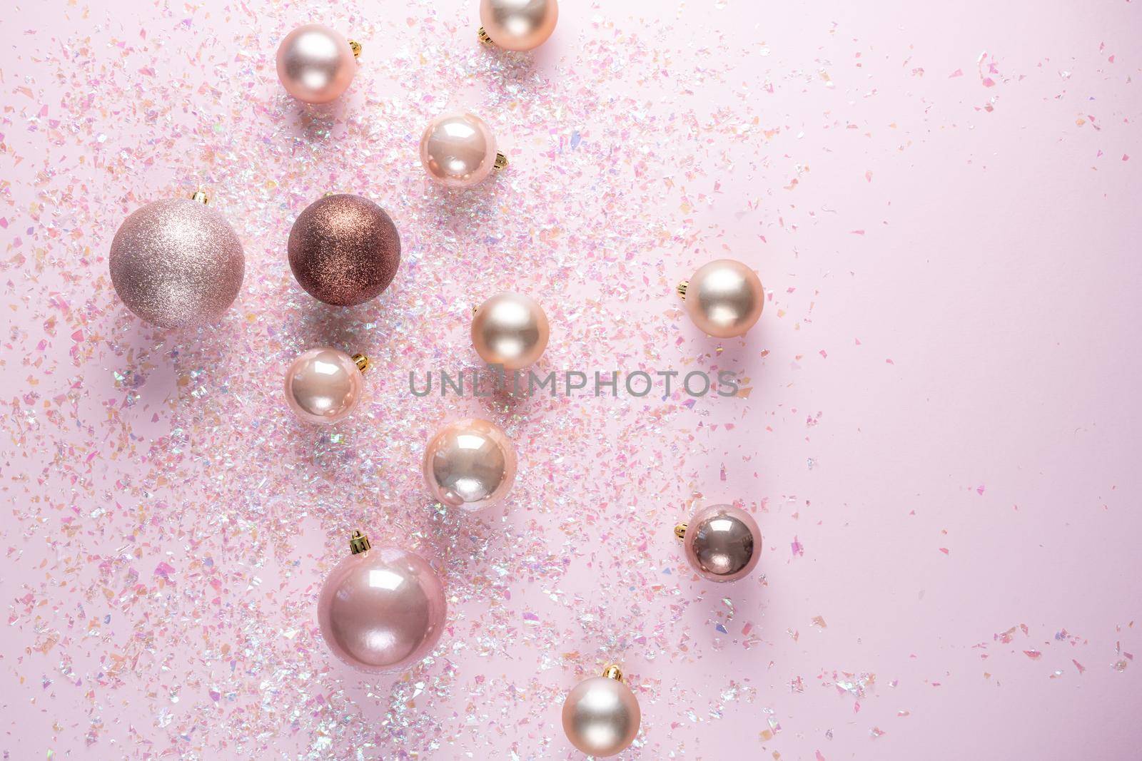 Christmas decoration of balls on pink background with tinsel. Flat lay with copy space by Mariakray
