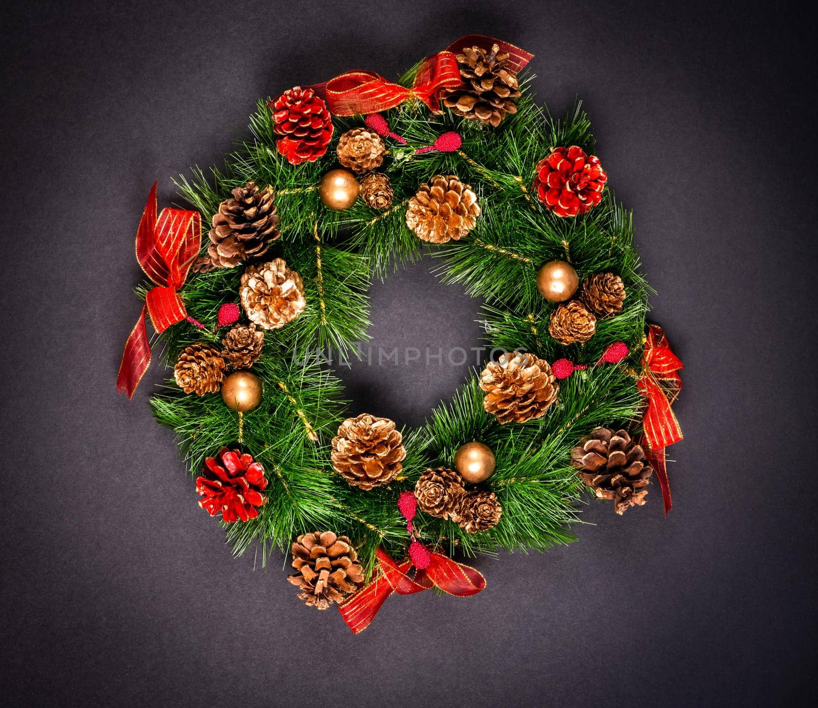 Christmas wreath with pinecones on black background by Mariakray