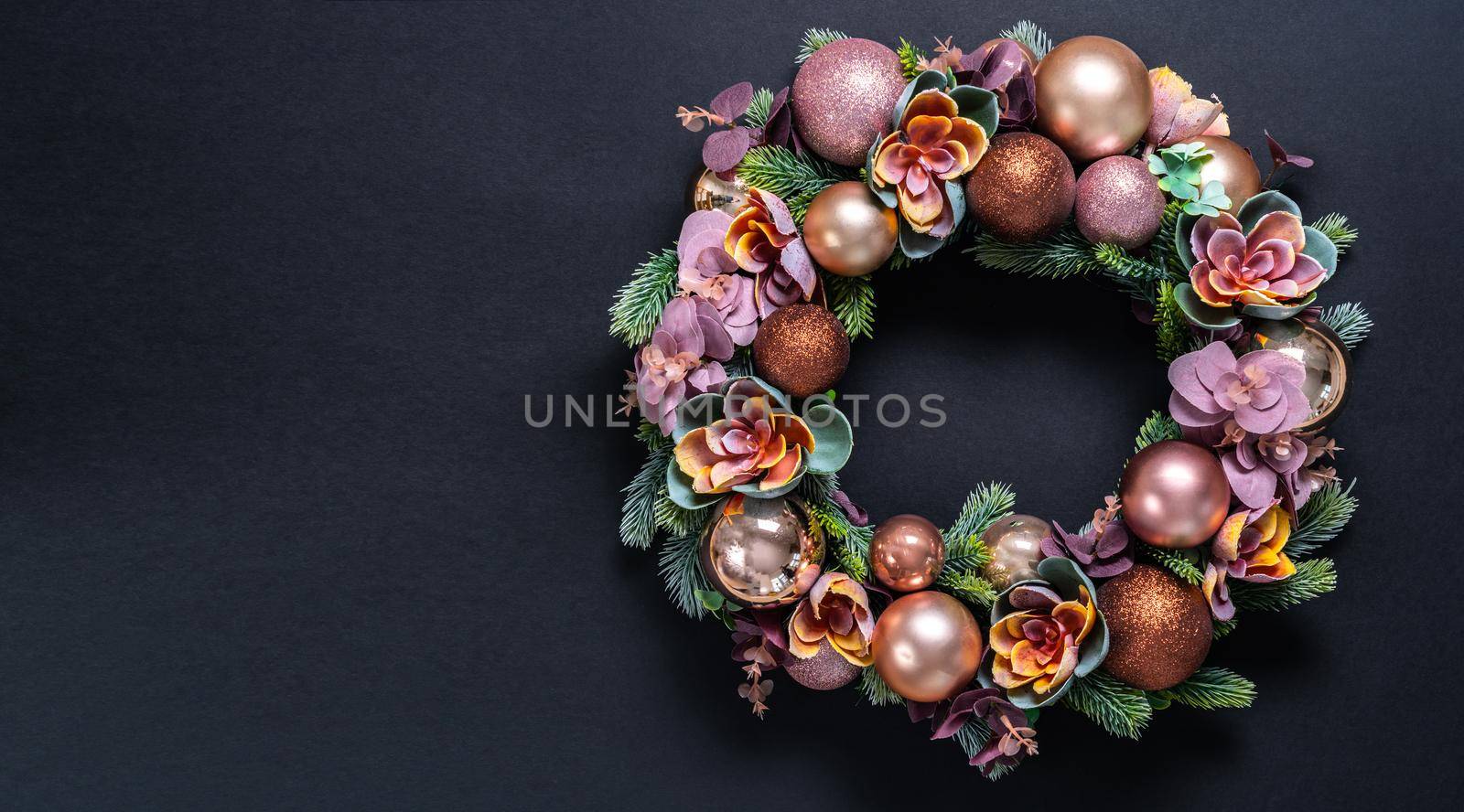 Beautiful unusual Christmas wreath hanging on pink wall