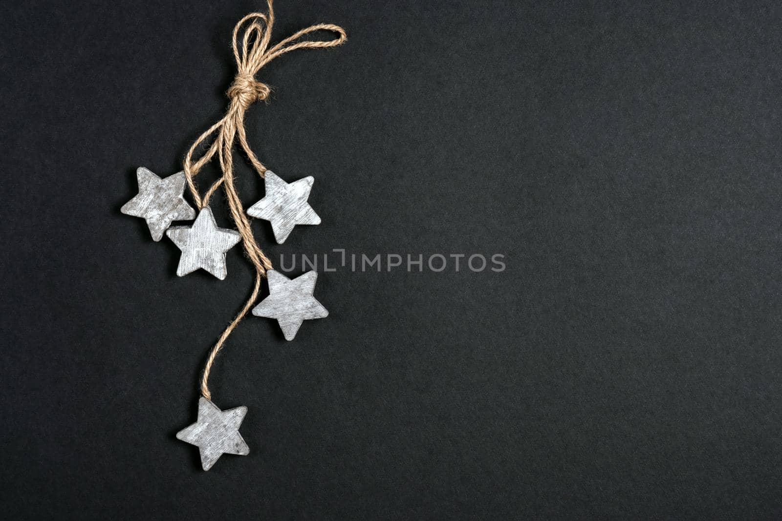Flat lay decor with wooden stars and rope over black background, top view with copy space by Mariakray