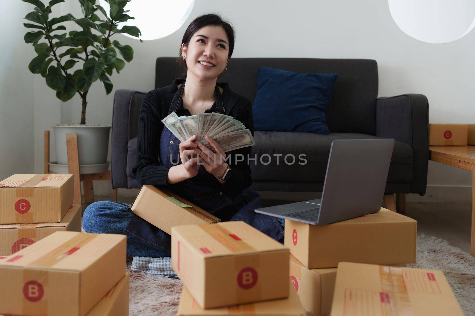 Asian SME business woman holding money and happy. online shopping concept.