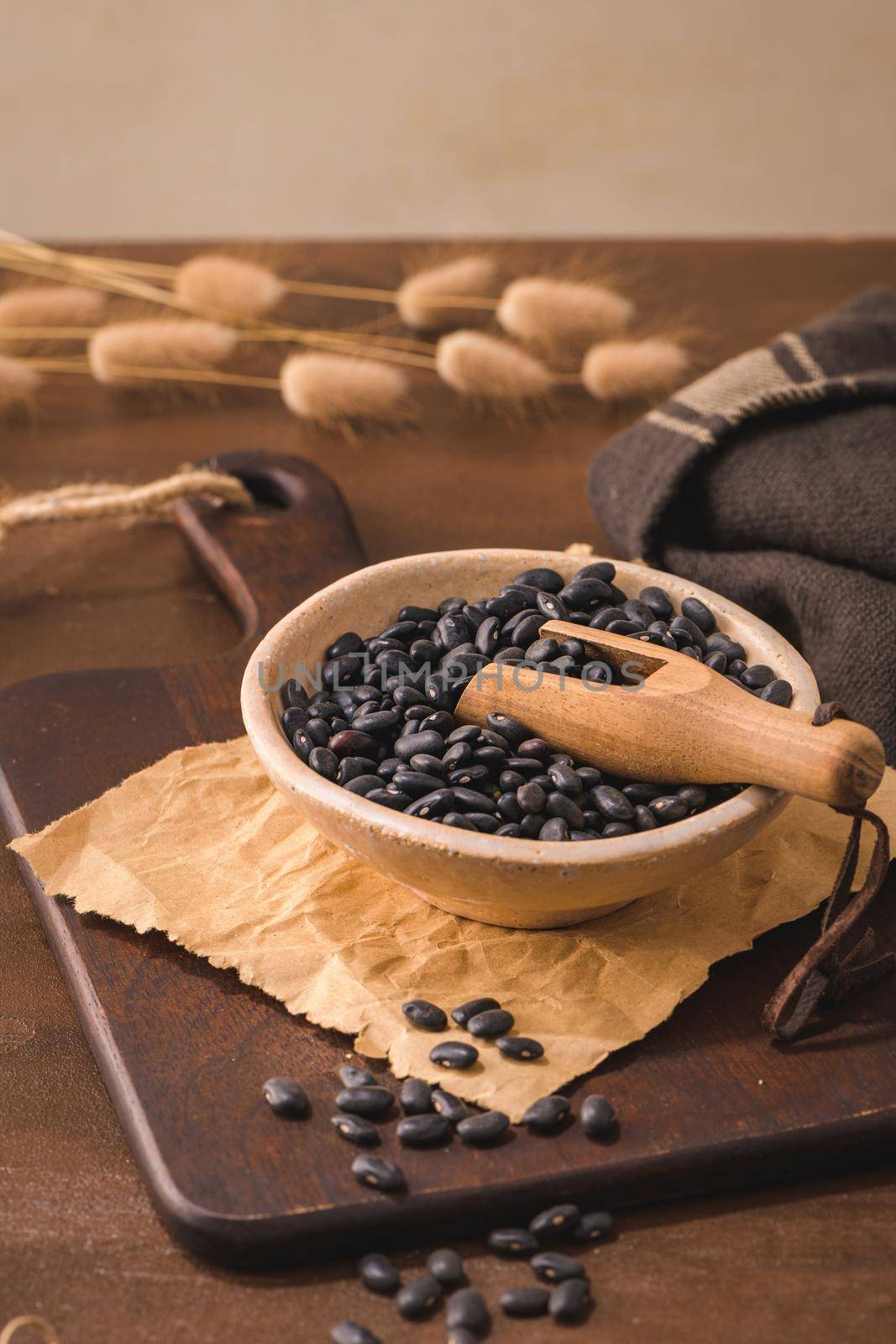 Black beans in a ceramic bowl on a rustic kitchen countertop.