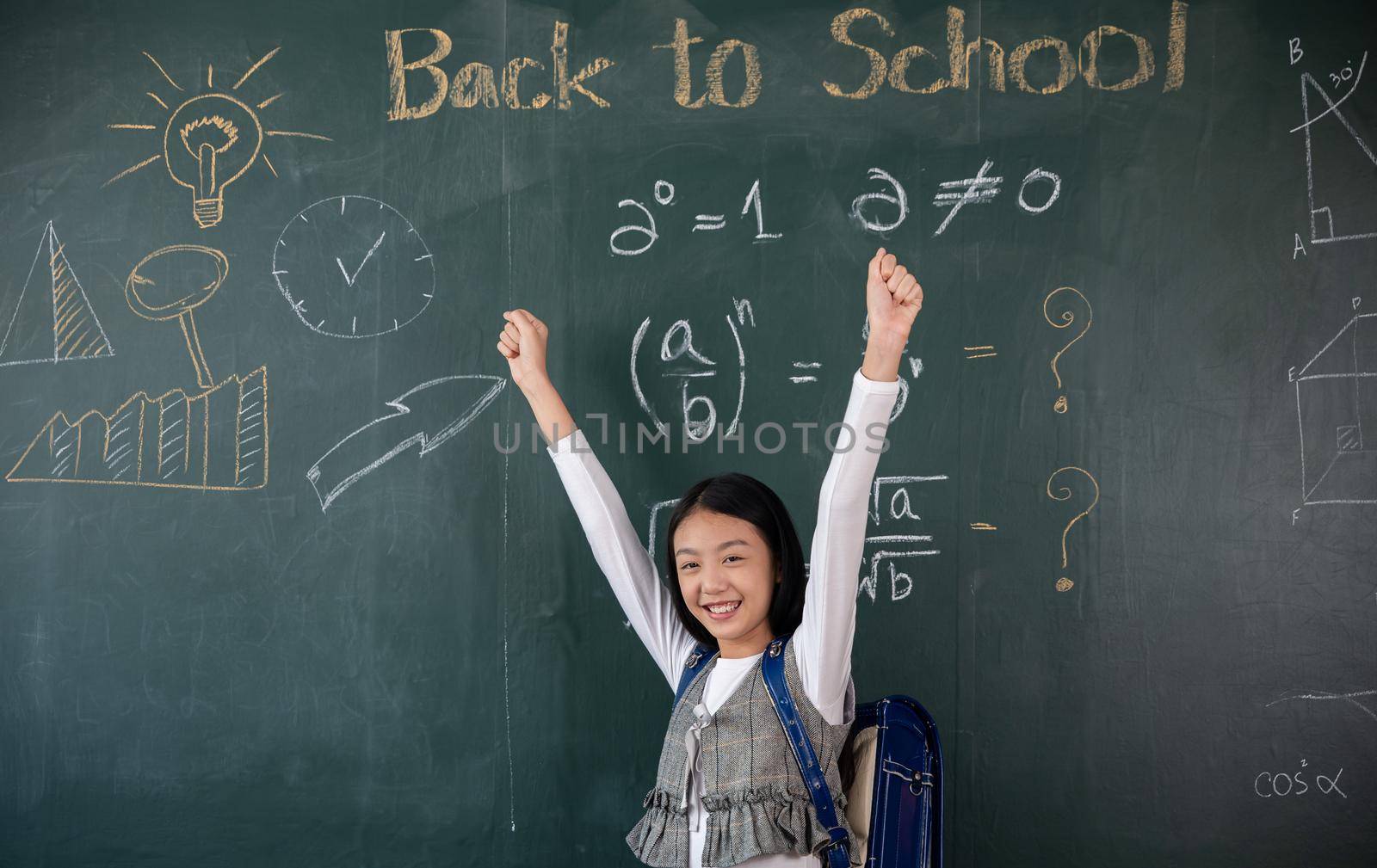 Asian school girl in uniform on classroom raised arms to successful finished homework by Sorapop