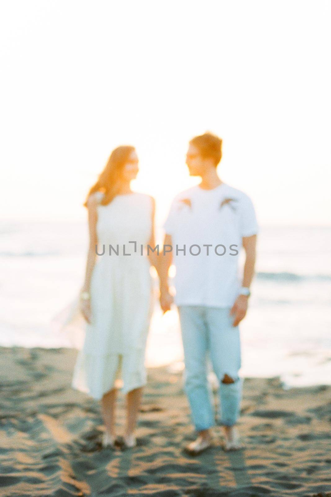 Silhouettes of a man and a woman holding hands near the sea. High quality photo
