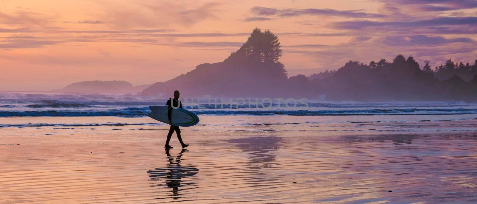 Tofino Vancouver Island Pacific rim coast, surfers with board during sunset at the beach by fokkebok