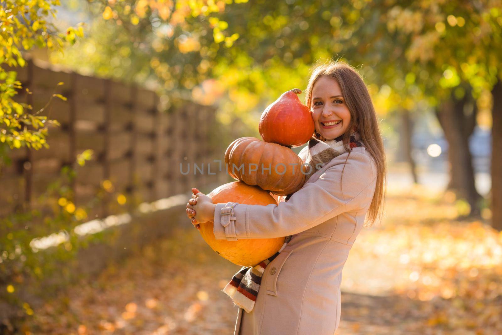 Portrait of happy smile woman with pumpkins in hand. by oksix