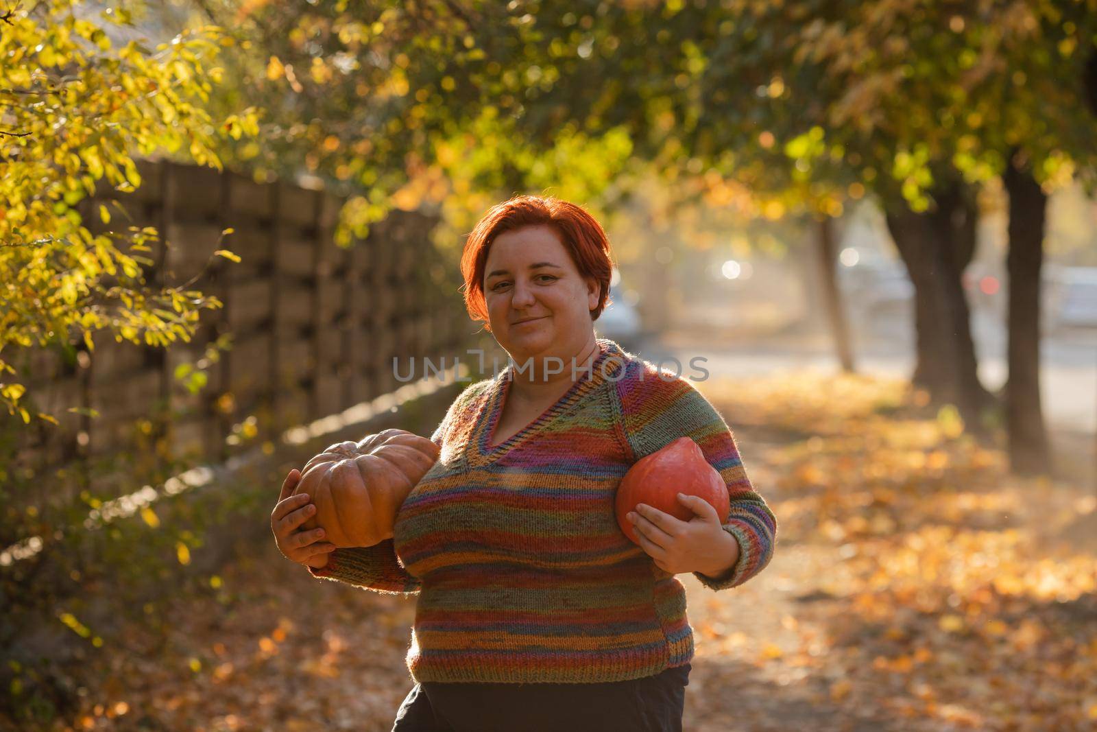 Portrait of happy smile woman with pumpkins in hand. Cozy autumn vibes Halloween, Thanksgiving day.