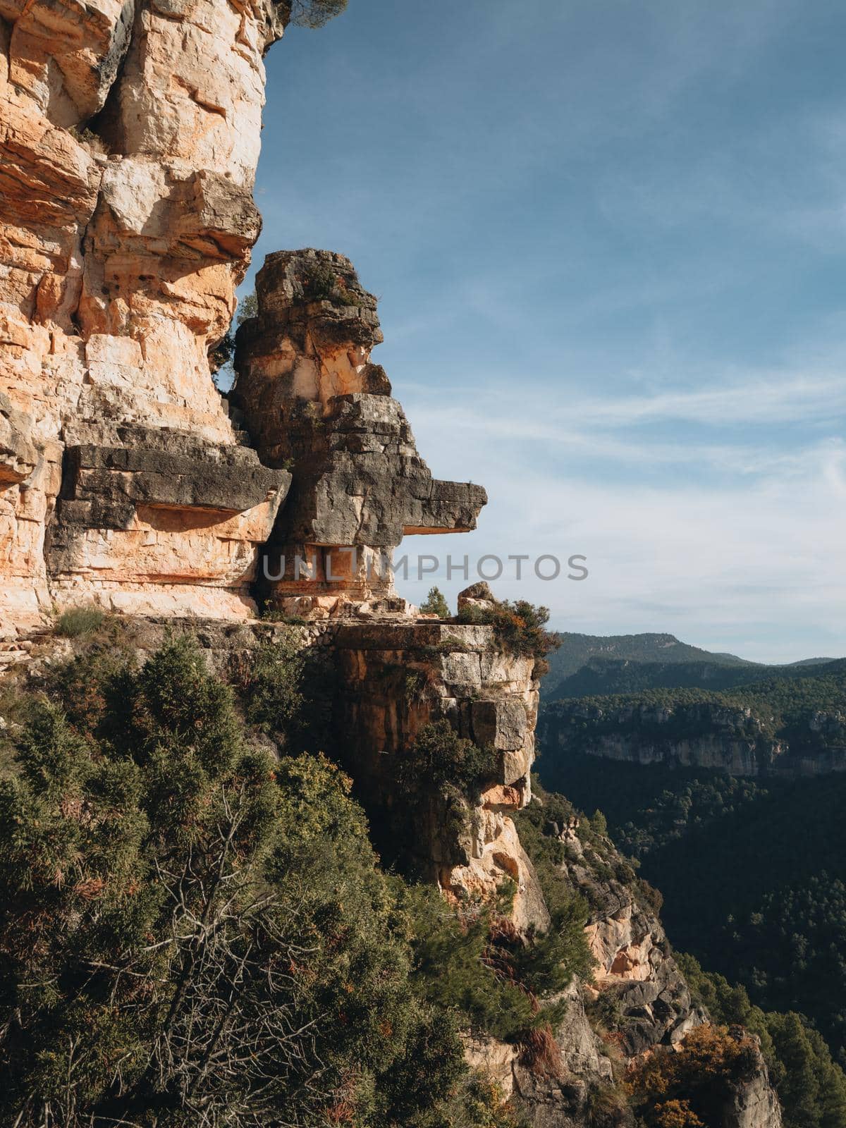 Rocky walls with reddish tones and pine forest in the Siurana mountains, Tarragona, Spain. by apavlin