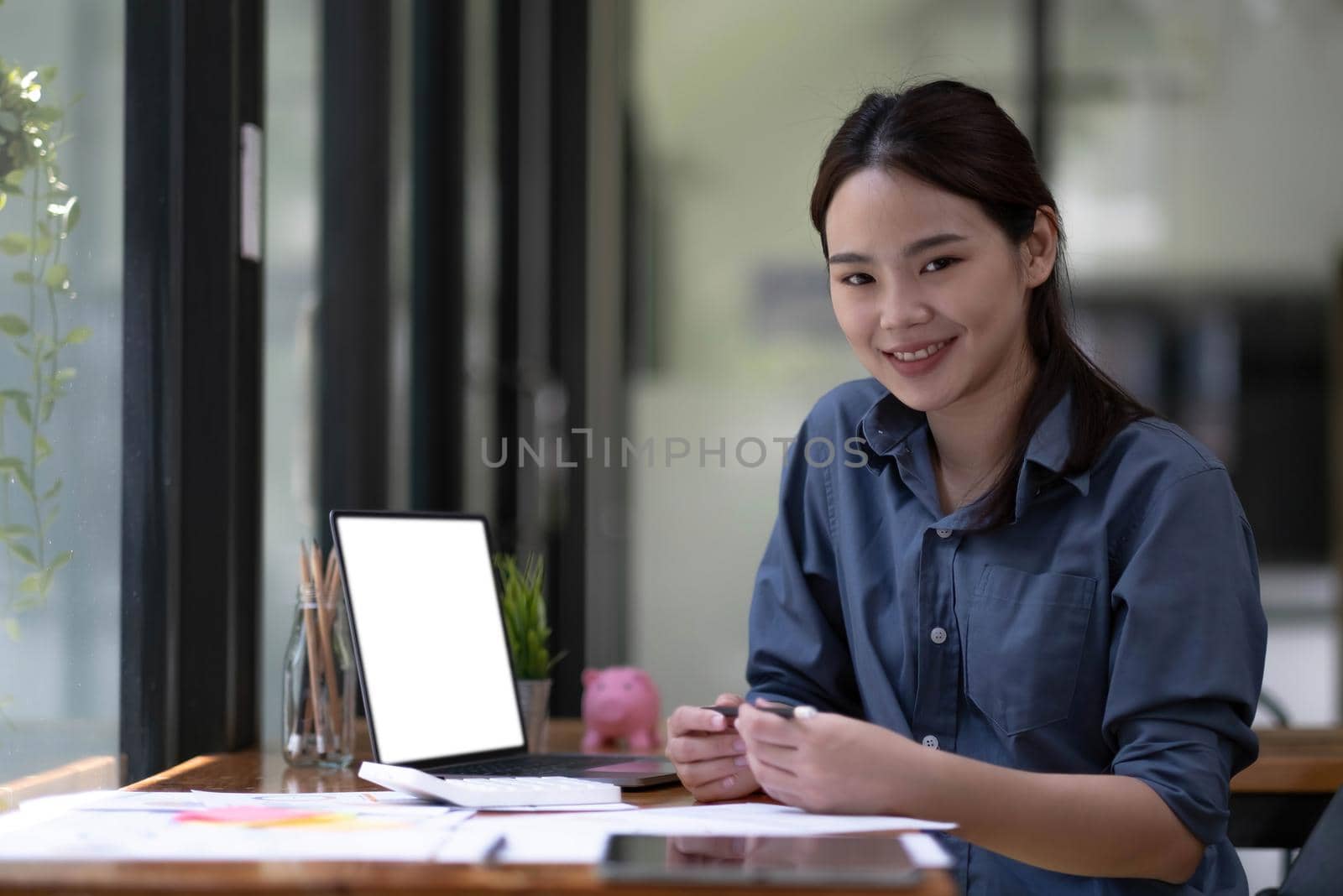 Shot of a asian young business Female working on laptop computer in her workstation.Portrait of Business people employee freelance online marketing e-commerce telemarketing concept..