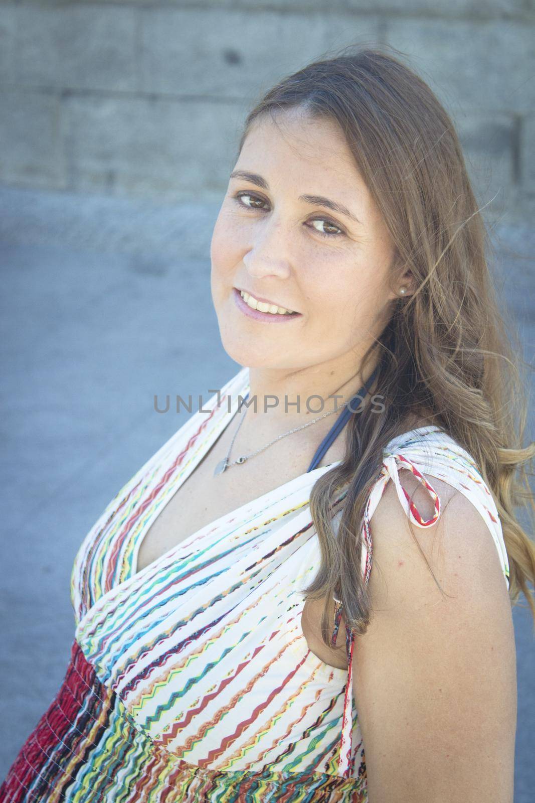 Seven month pregnant woman outdoors in multi colored striped dress by GemaIbarra