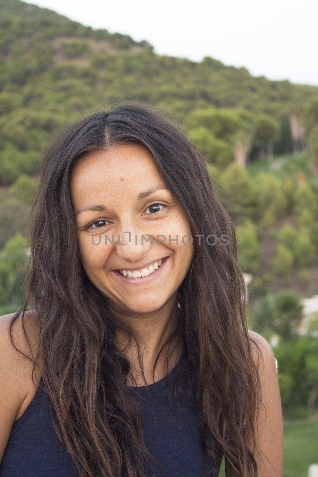 Portrait of youthful woman on mountain background. Smiling.