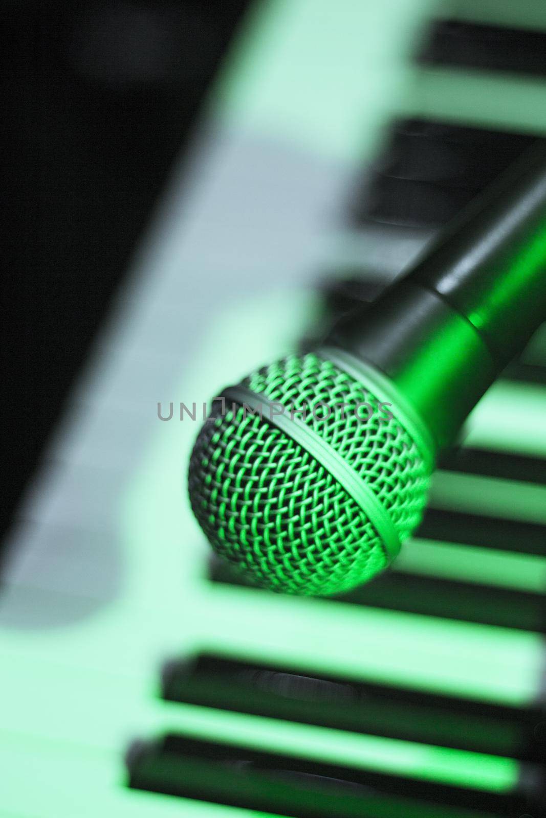 Microphone over piano keys in dim light by GemaIbarra