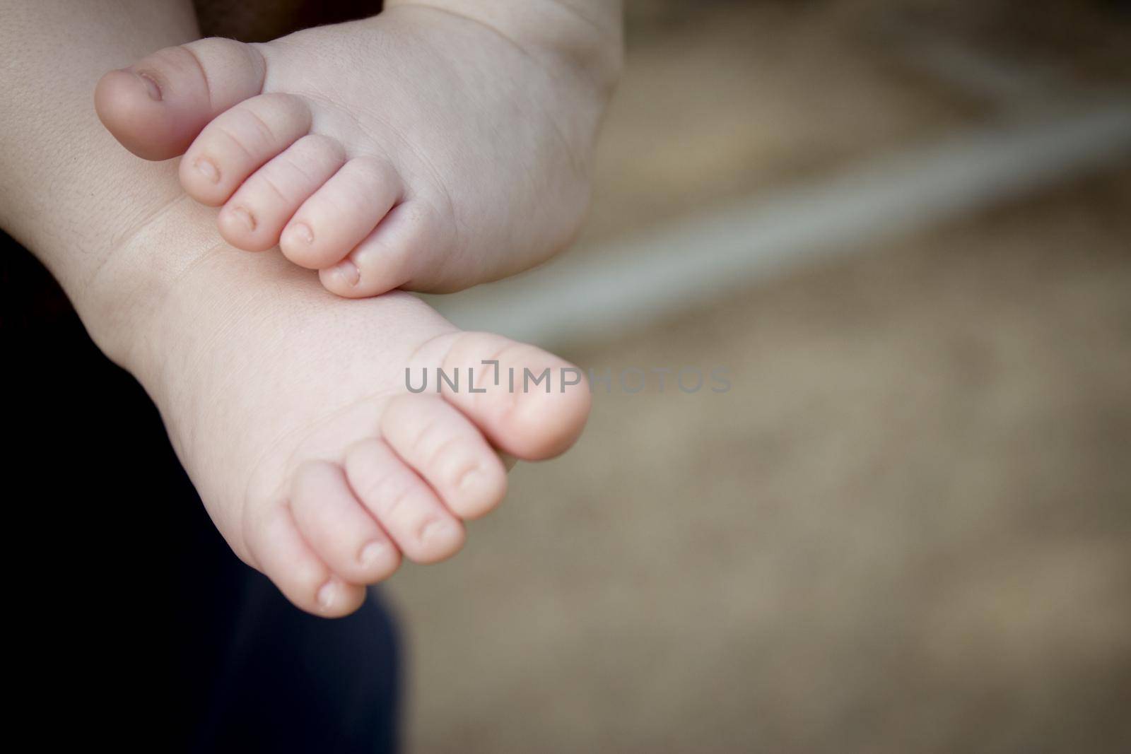 Two month old baby feet on black background. Sweet scene