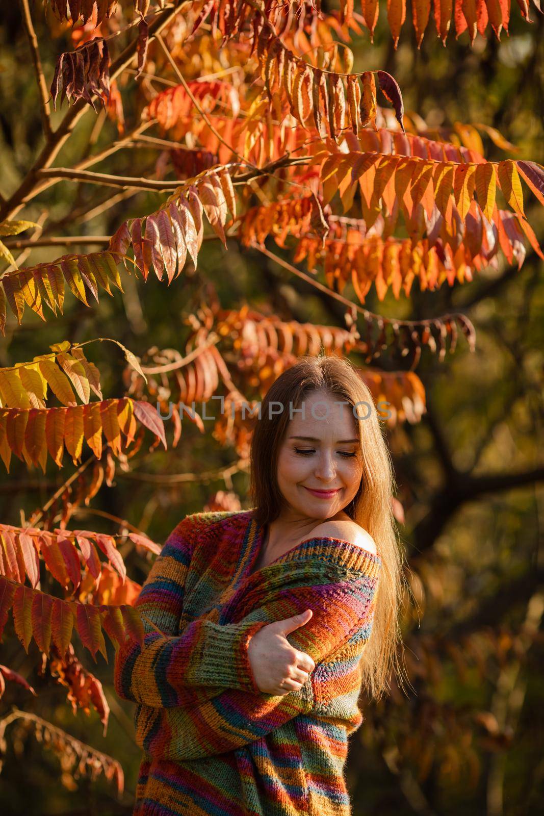 Happy woman wearing warm clothes in the autumn park