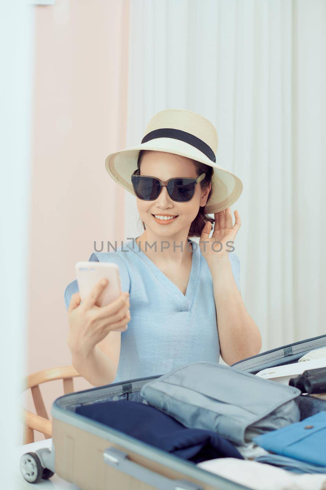 young woman preparing and packing clothes into suitcase on a bed at home, holiday travel concept