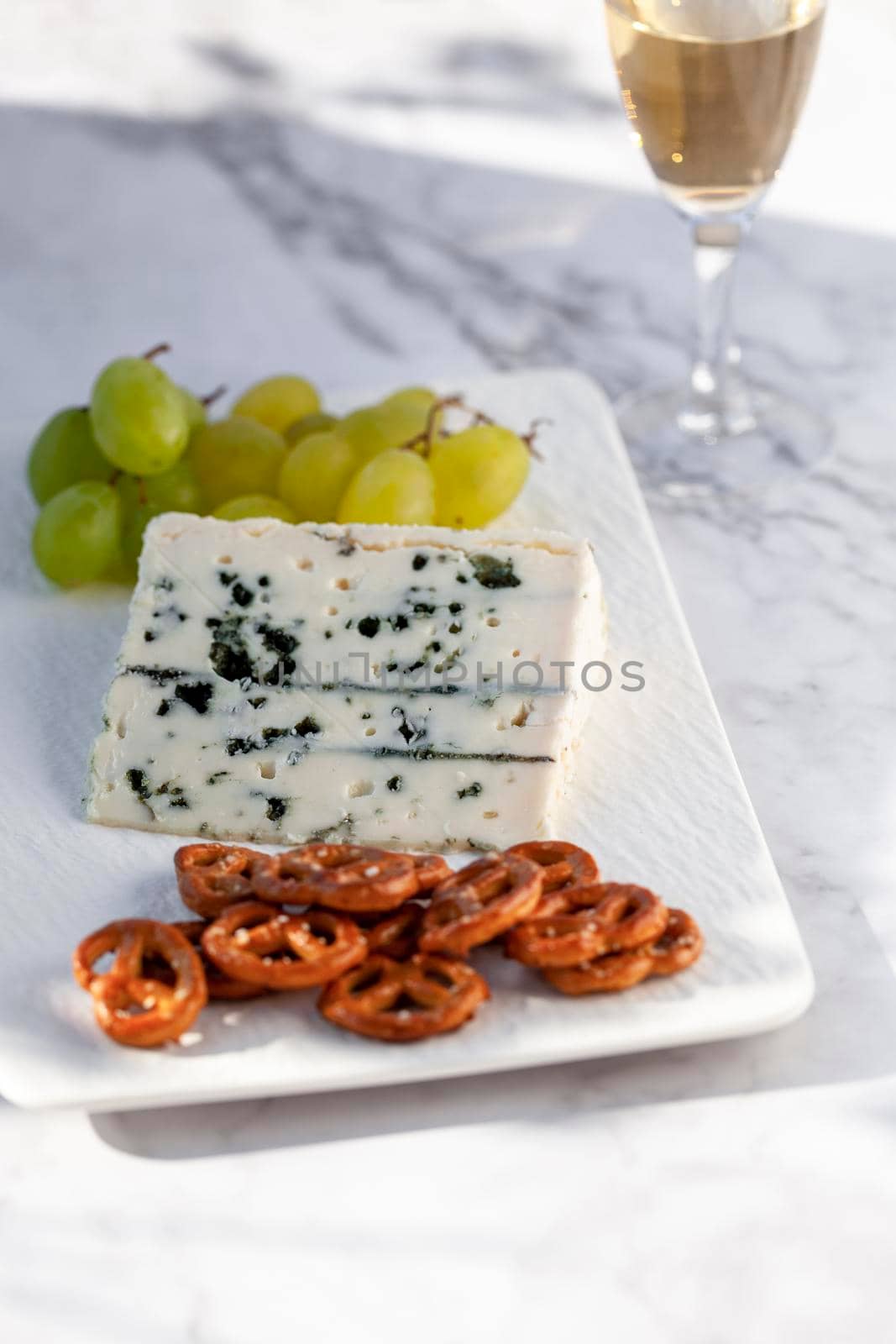 roquefort cheese served with green grapes and snacks outdoors, hard light
