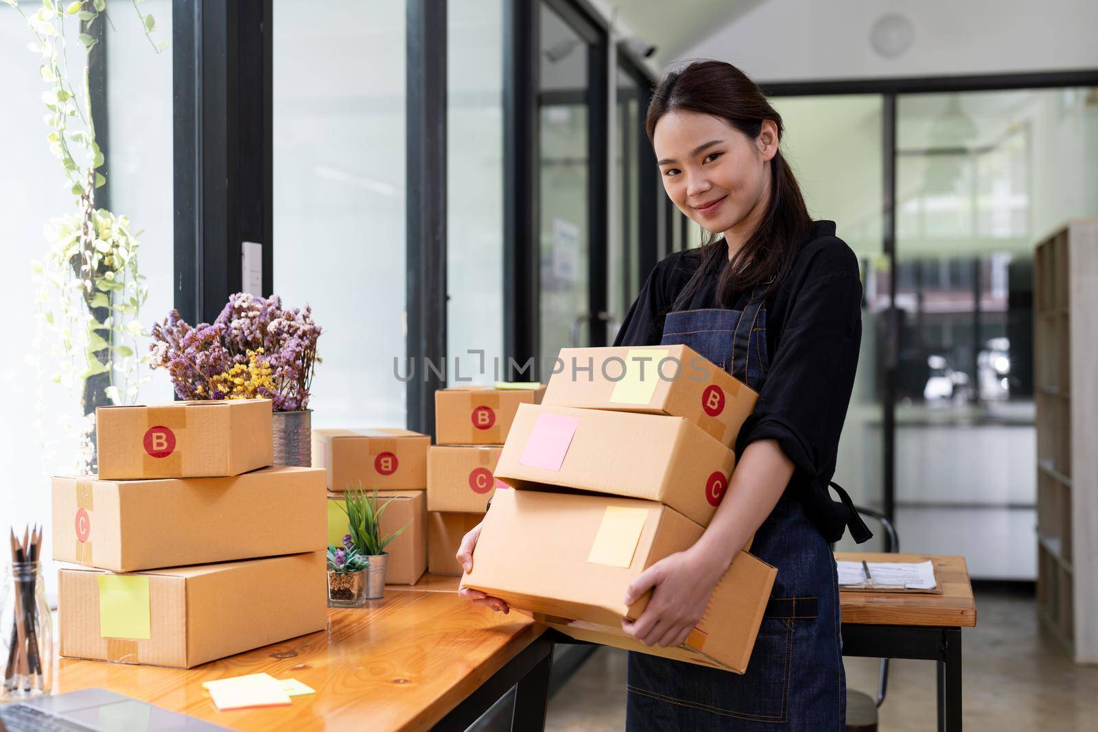 businesswoman start small business and successful SME entrepreneurs A woman works from home delivering parcels online. SME delivery concept and packaging.