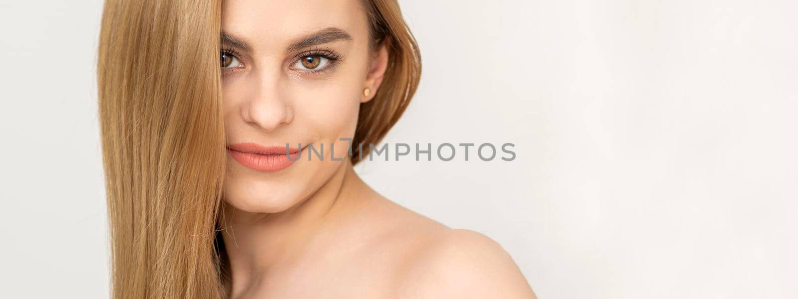 Beautiful caucasian young woman with one tulip against a white background