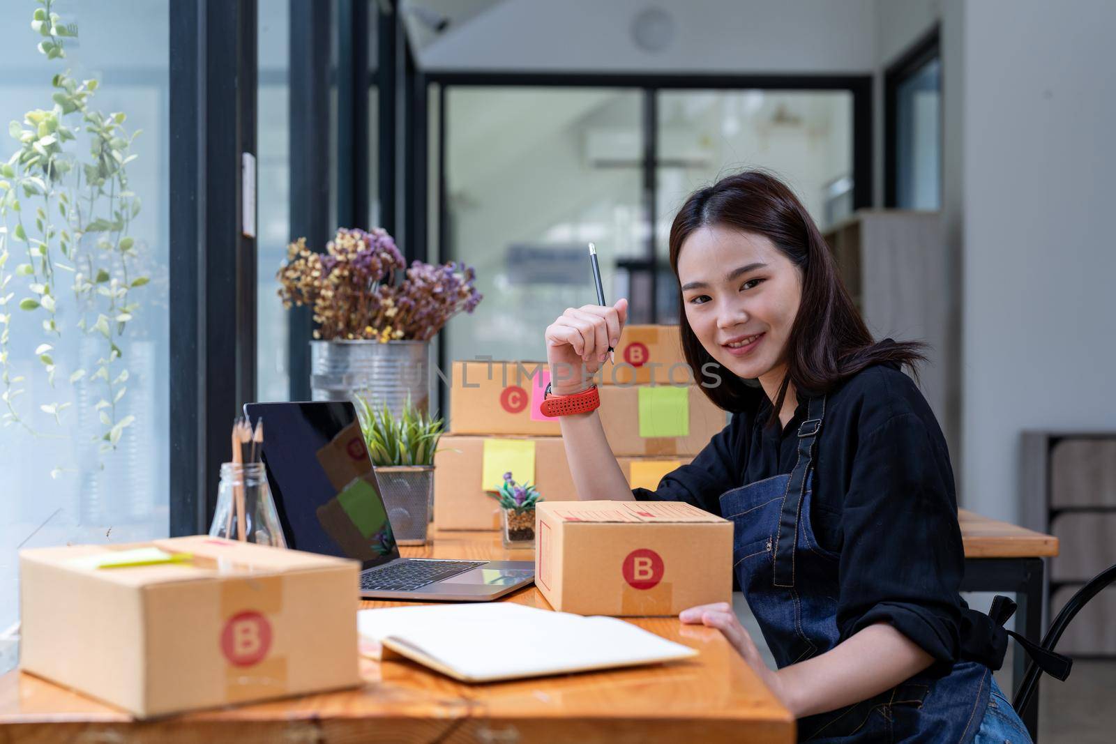 Freelance woman working at home with Online Parcel delivery. SME and packaging delivery concept.
