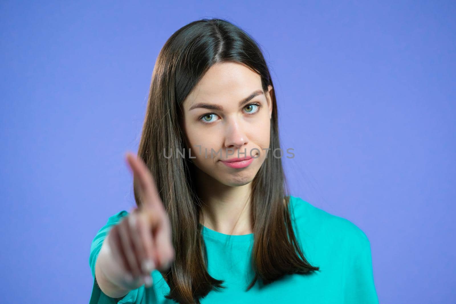 Portrait of serious woman showing rejecting gesture by stop finger sign. Girl isolated on violet background. by kristina_kokhanova