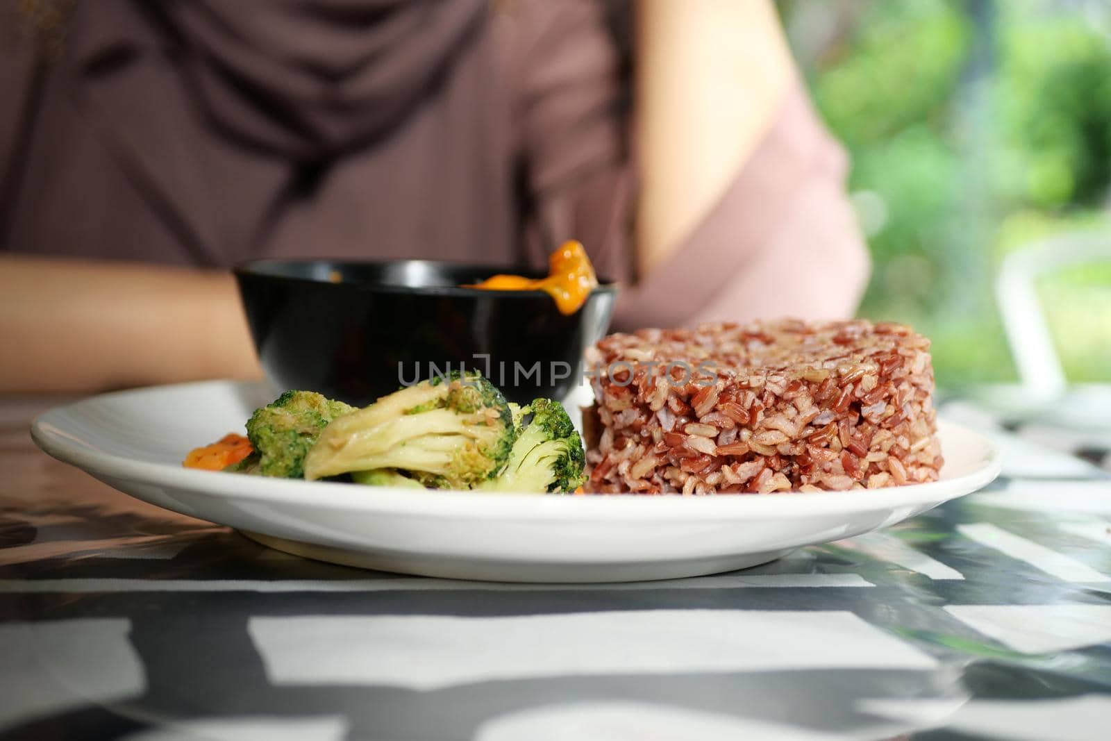 cooked red rice and vegetables on a plate ,