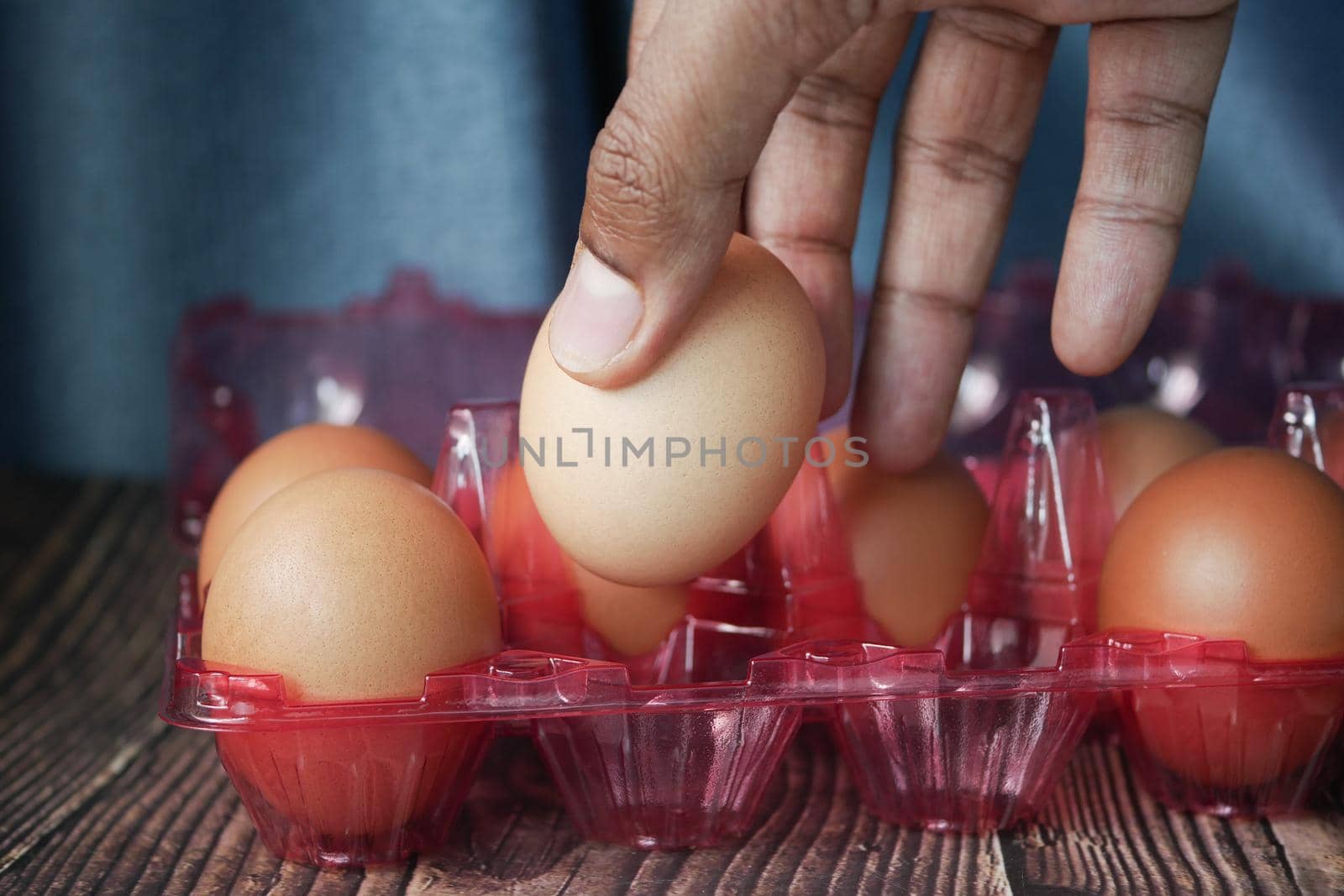 hand pick eggs from a plastic case on table ,