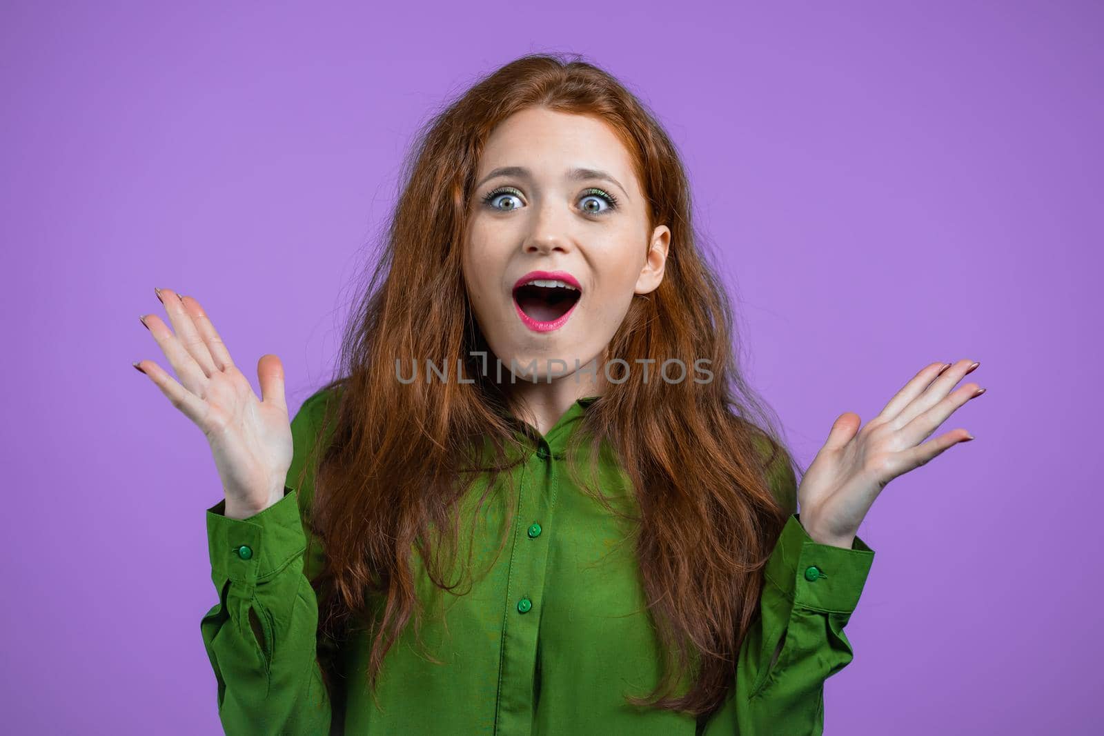 Young woman is very glad, she screaming wow loud. Concept of sales, profitable offer. Excited happy lady on violet studio background. High quality photo