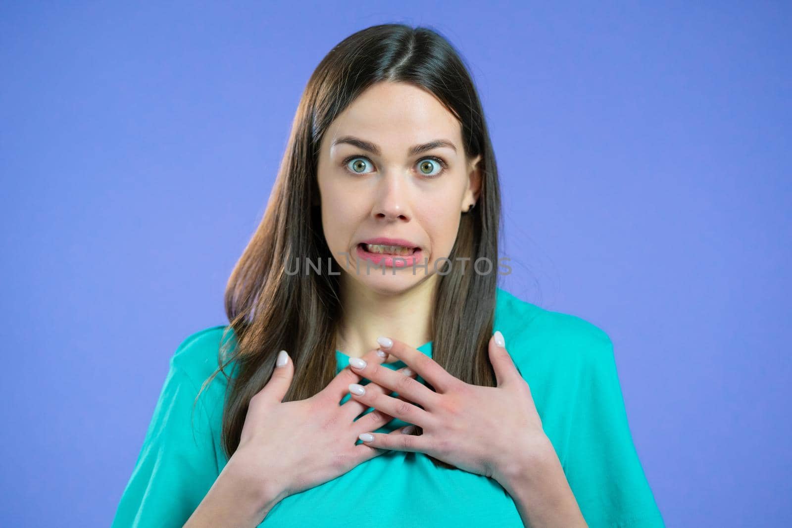 Portrait of unpleasantly surprised and shocked girl on violet studio background. Woman receiving bad news. She expresses sympathy and regret. by kristina_kokhanova