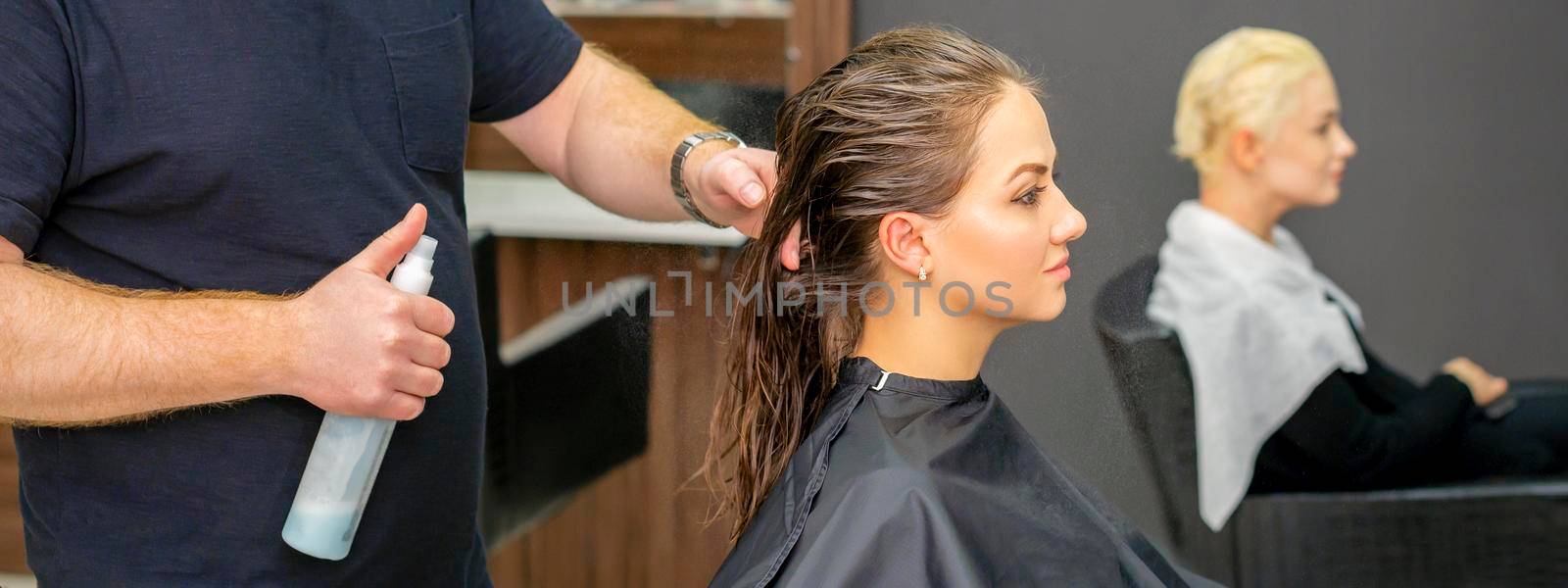 Hairdresser sprays water long hair by okskukuruza