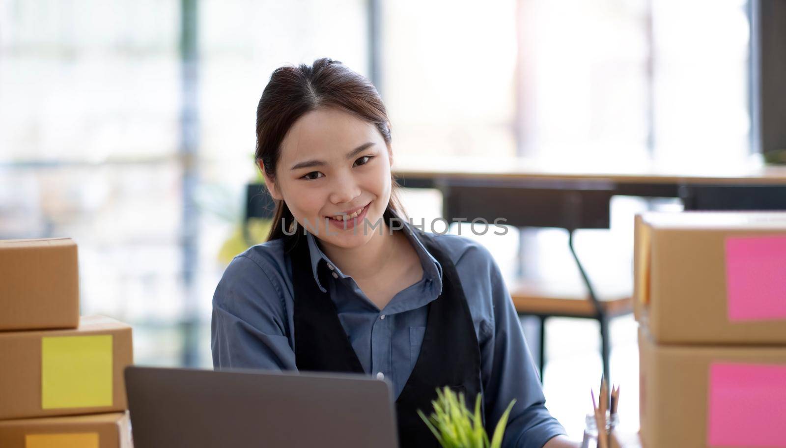 Portrait of Starting small businesses SME owners, Asian woman check online orders Selling products online and working with boxs freelance work at home Asian sme business online small medium enterprise.