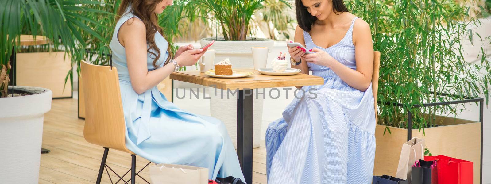 Two women looking at smartphones by okskukuruza