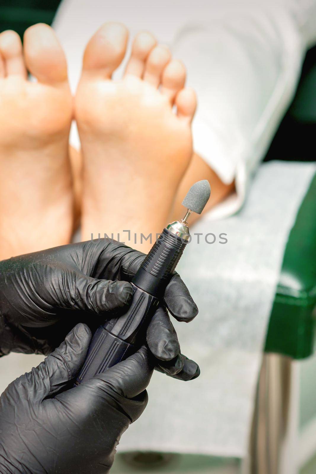 Chiropodist master prepares foot file machine before foot and toes clean treatment in a beauty salon
