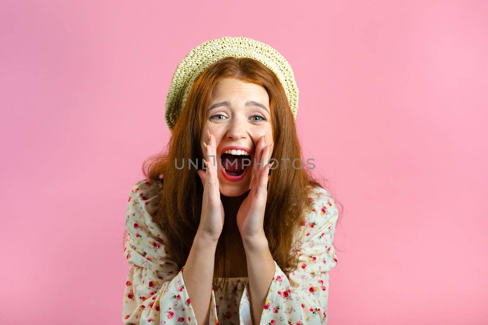 Woman with red hair very glad, she screaming loud. Woman trying to get attention. Concept of sales, profitable offer. Excited happy lady on pink studio background. by kristina_kokhanova