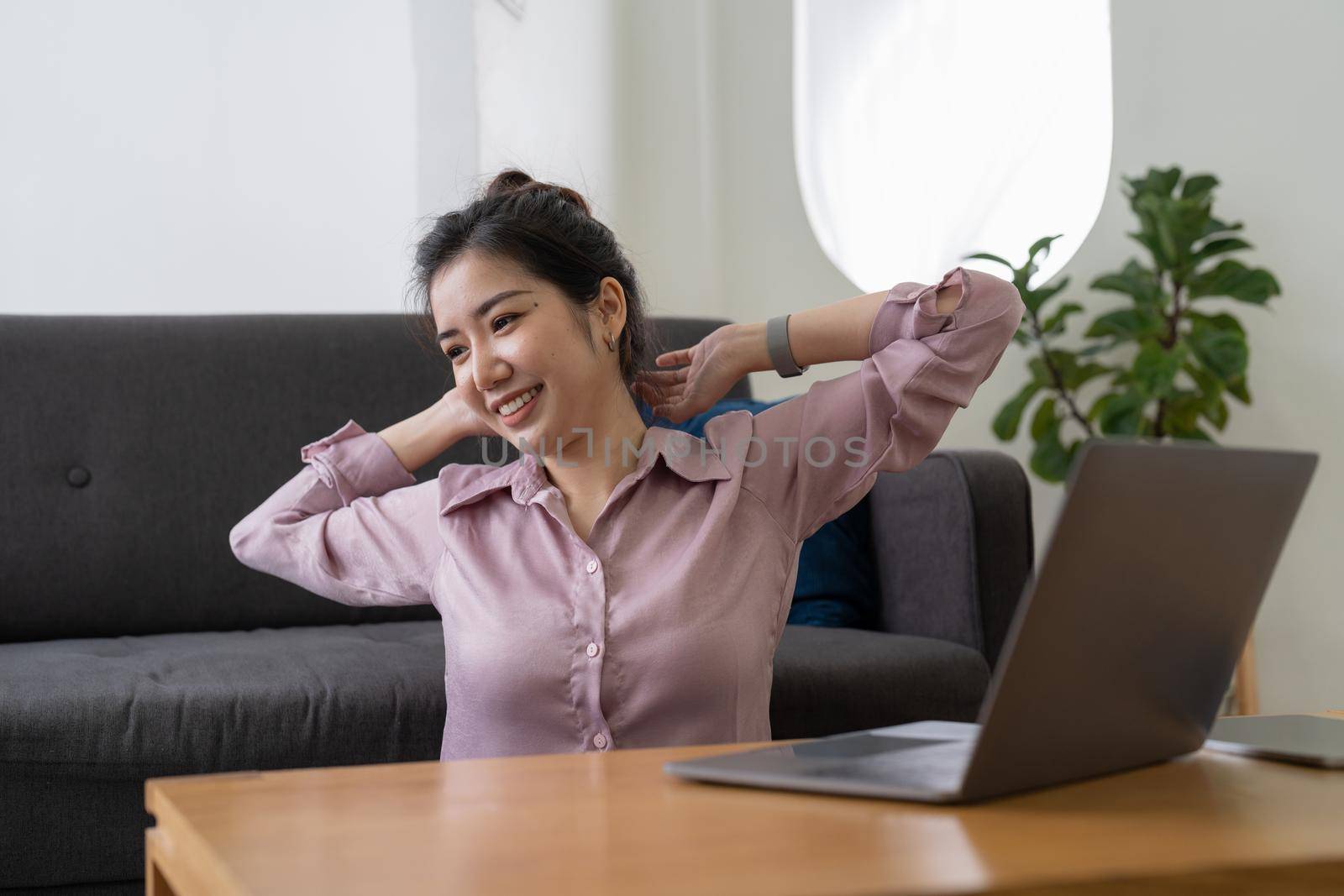 A business woman working in an office stretches to relax from work during breaks at home.