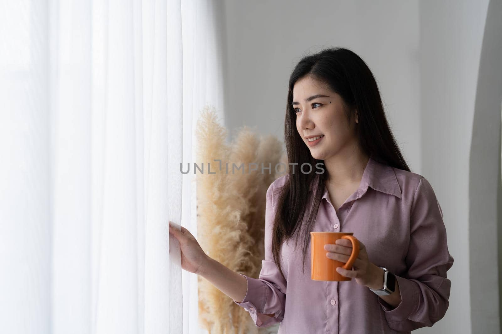 Portrait of young asian woman in casual wear. smiling while standing in modern office room