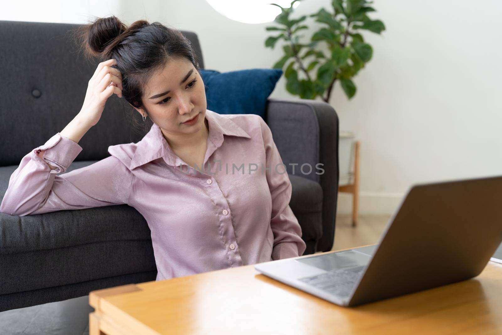 Stressed asian woman having headache while working using laptop computer at home. stressed and depressed.