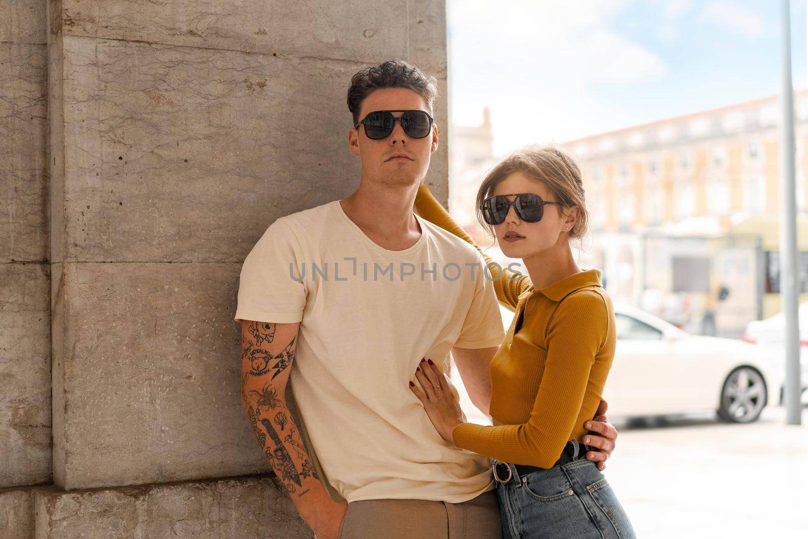 Young beautiful hipster couple in love walking on old city street, summer Europe vacation, travel, fun, happy, smiling, sunglasses, trendy outfit, romance, date, embracing