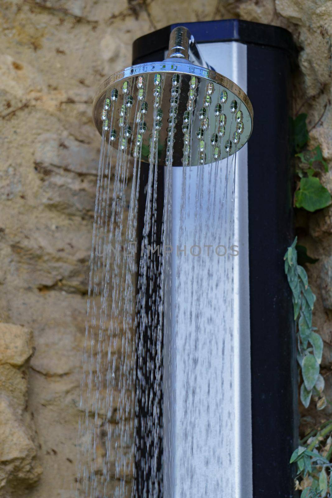 outdoor shower running water over a stone wall