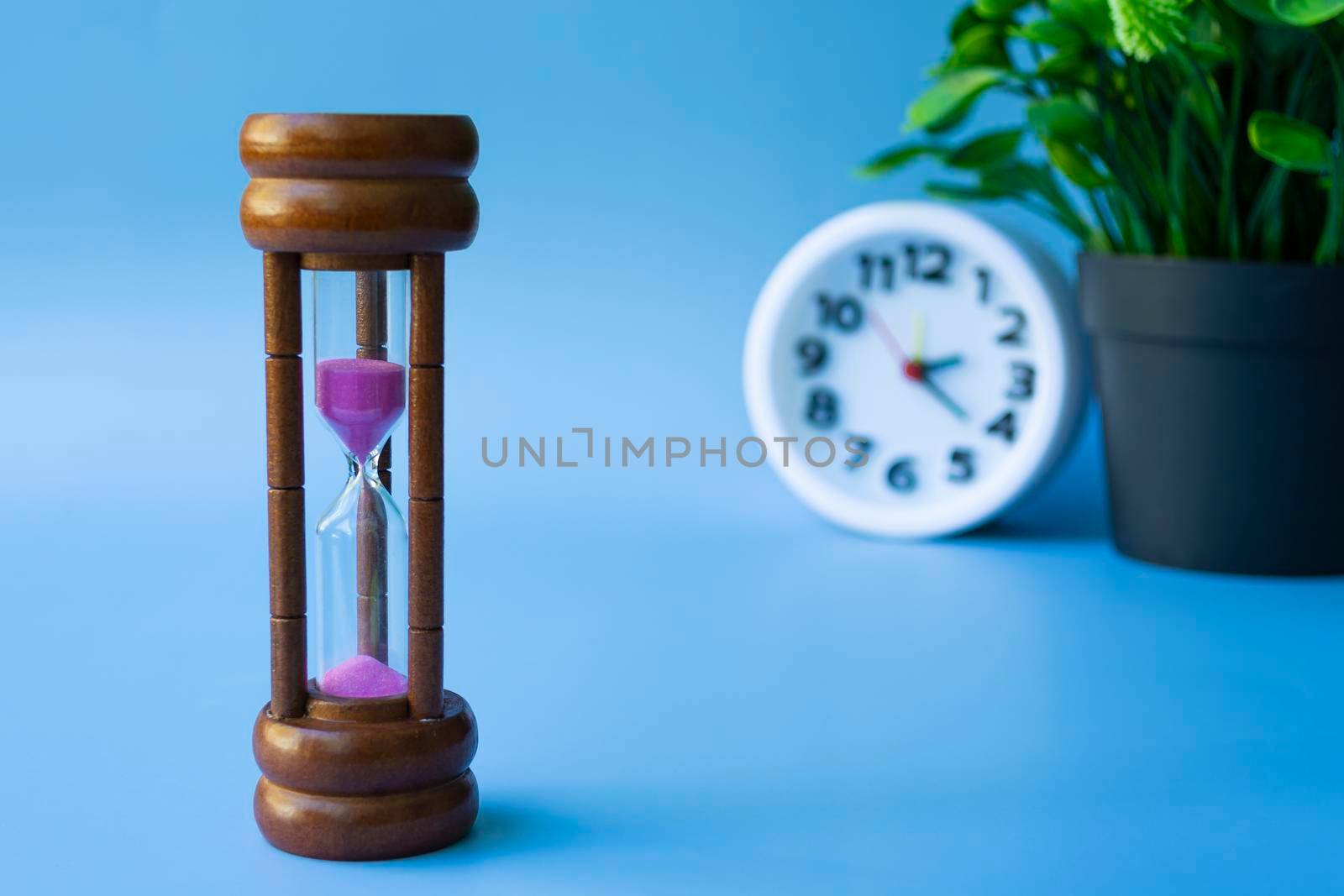 Hourglass as time passing concept for business deadline and running out of time. Copy space.