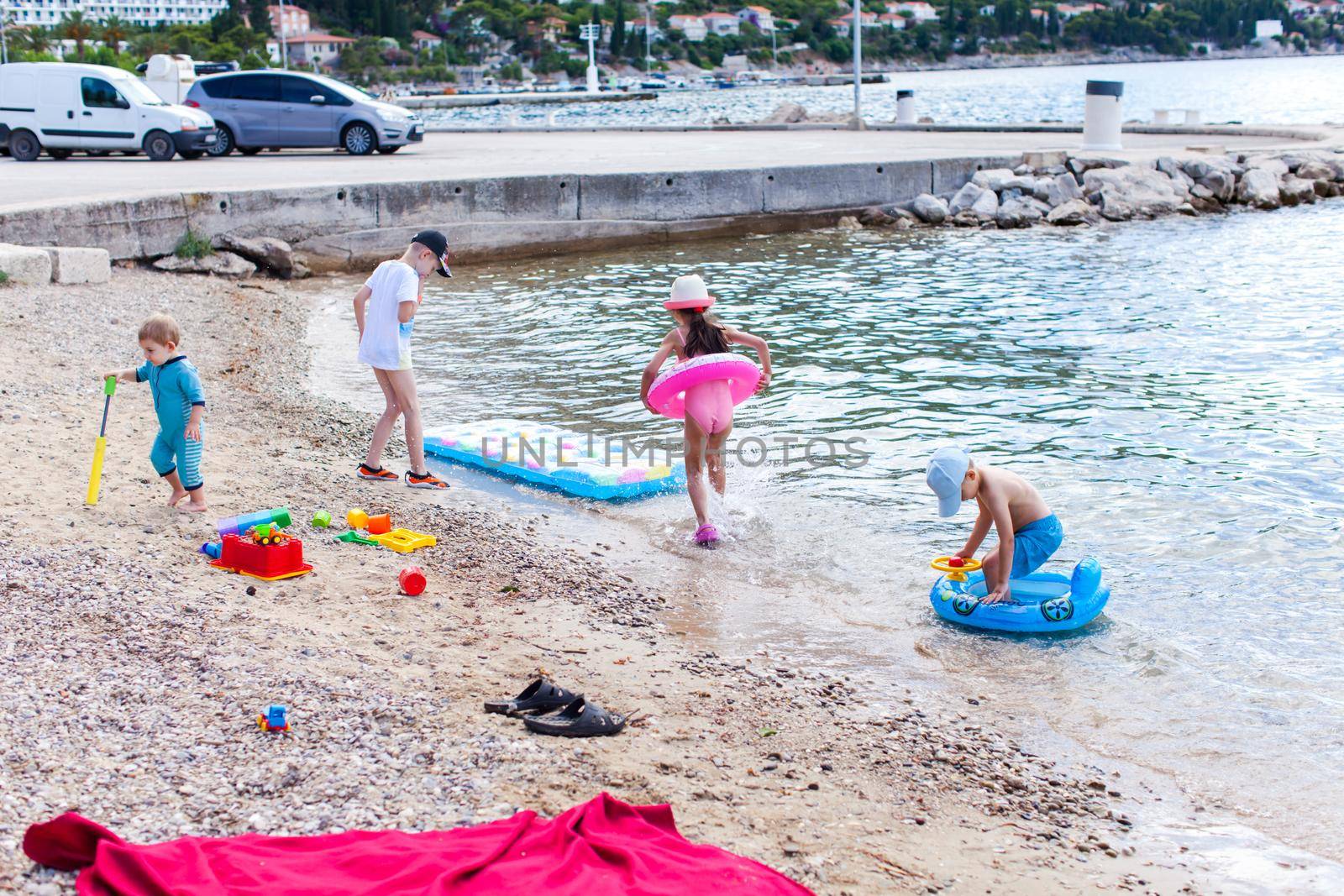 Group of kids play at the beach in summer, Adriatic sea