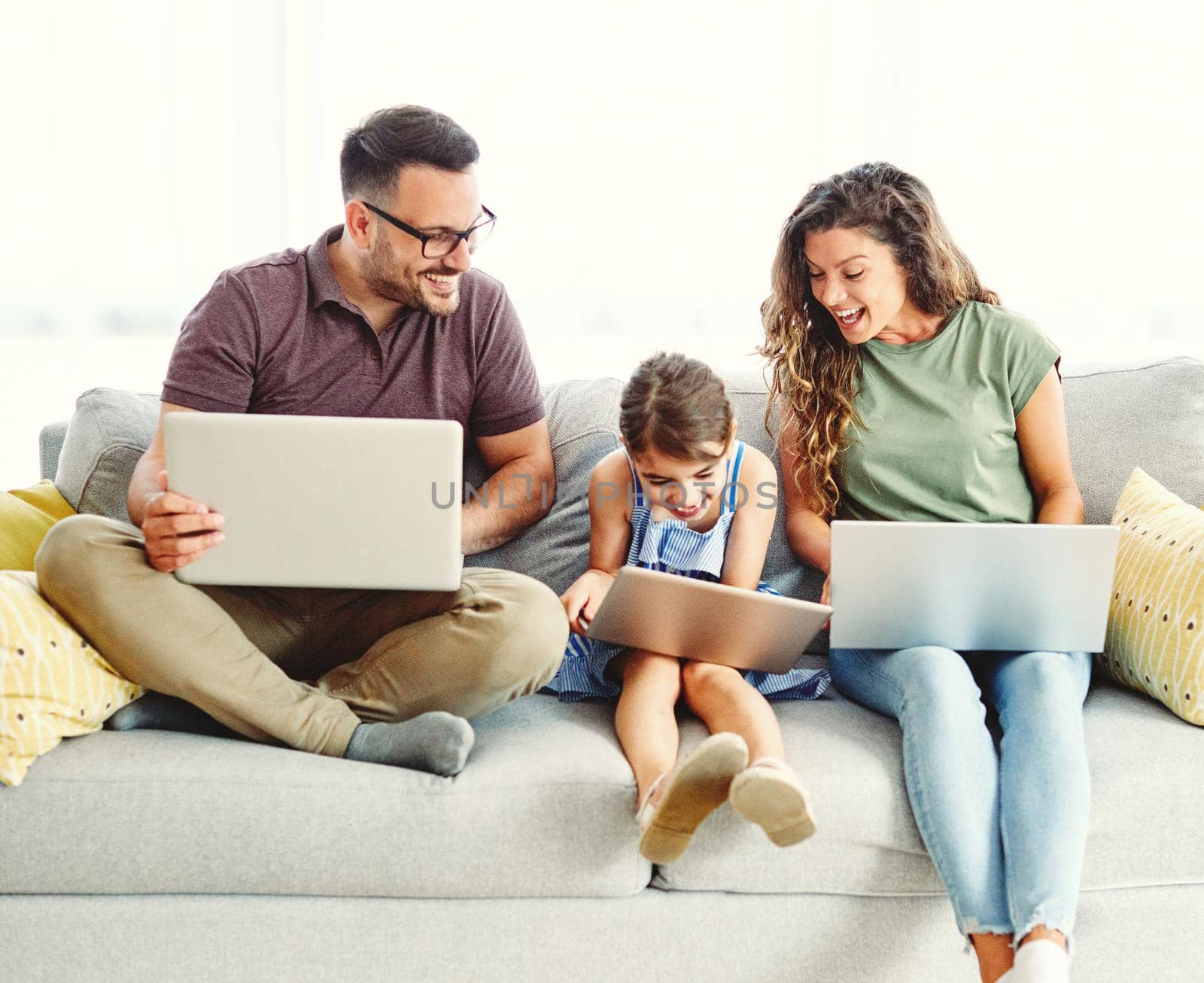 child laptop family computer woman mother father happy home man technology daughter together internet by Picsfive