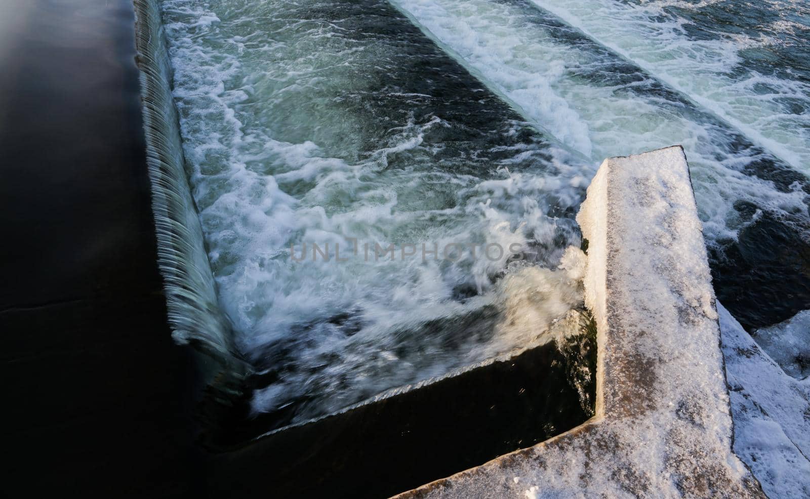 Water Cascading over Weir Step in river canal.