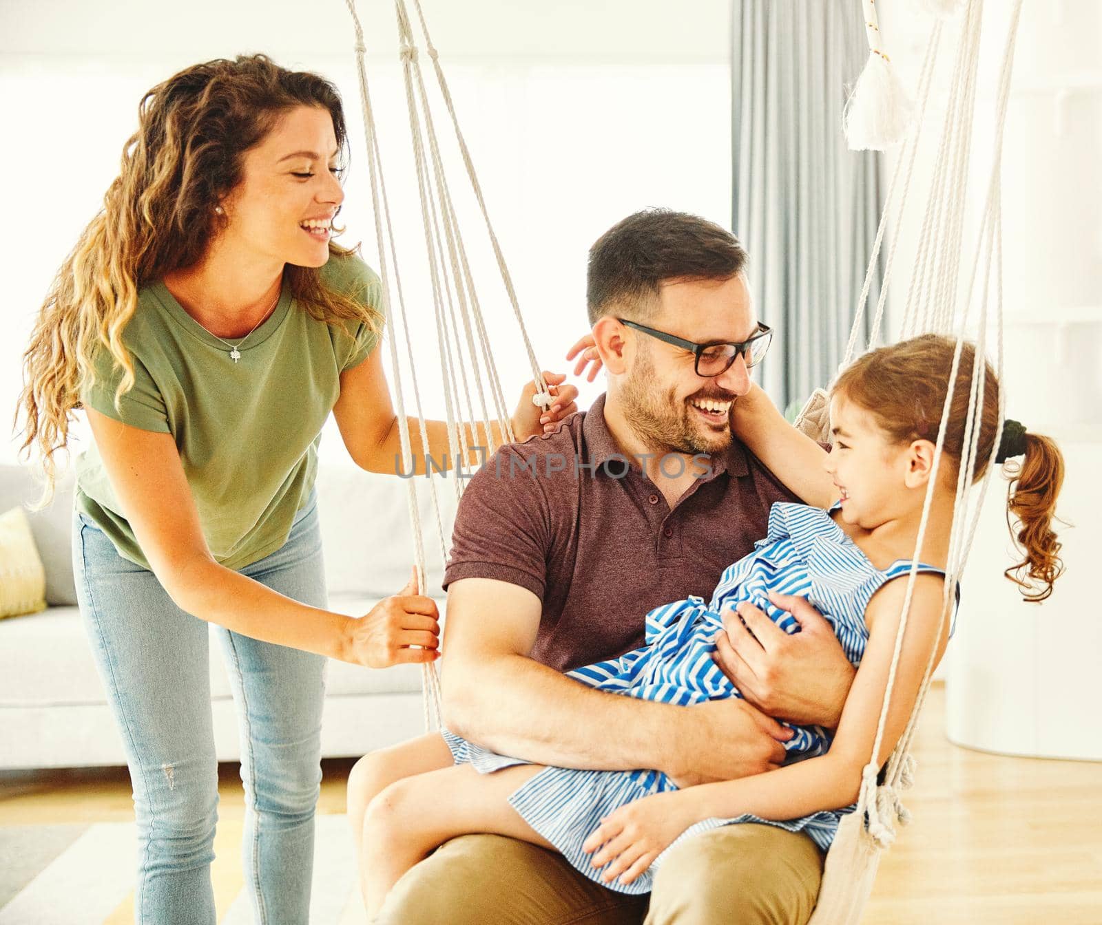 Family having fun playing on a swing at home