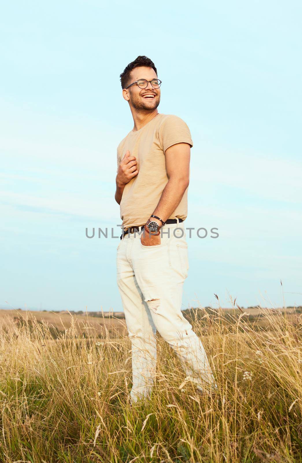 Portrait of a young man fashion model outdoors in the field